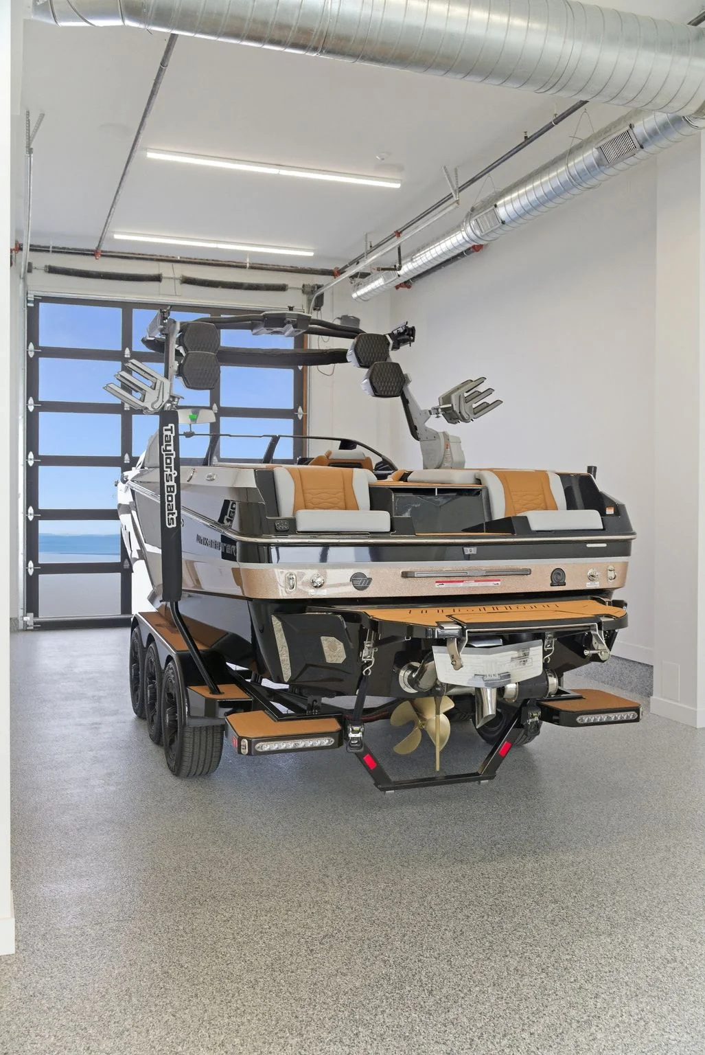 Drive-through garage with 18-foot ceilings storing a boat on a trailer